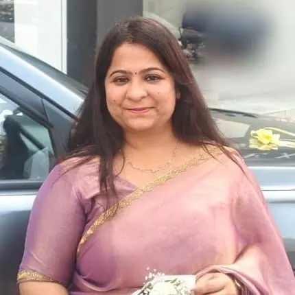 Pooja Kothari, owner of D&S Beauty Care, smiling in a mauve saree