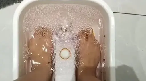 Feet soaking in a warm foot bath at the start of a pedicure